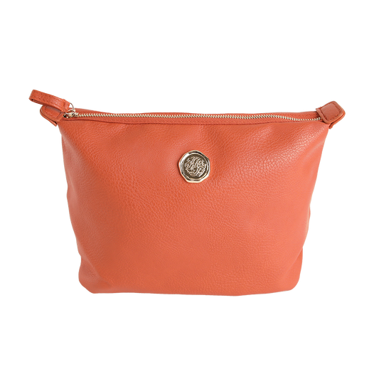 The Tangerine Orange Large Cosmetic Bag is crafted from high-quality faux leather and features a gold circular emblem at the center. Showcased against a plain white background, this spacious travel cosmetic bag highlights its sleek zippered design.