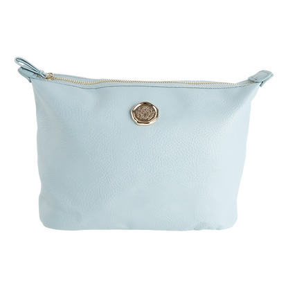 Introducing the Beach Glass Blue Large Cosmetic Bag, crafted from blue faux leather with a textured surface and finished with a round gold emblem at the center. This spacious pouch features a gold-toned zipper along the top edge, making it an ideal and stylish choice for organizing your travel makeup essentials.