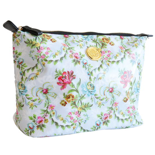 A floral patterned Phoebe Large Cosmetic Bag with a zipper and a branded gold emblem on the front.