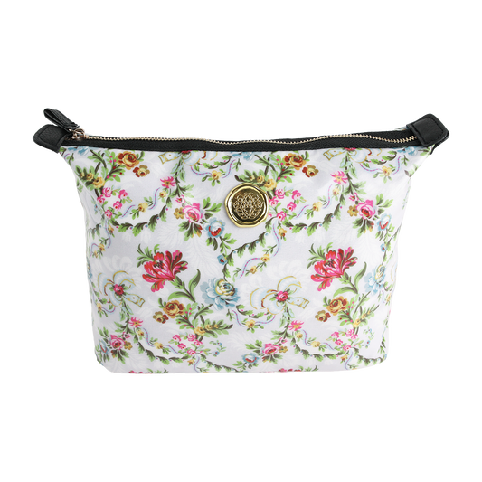 The Phoebe Large Cosmetic Bag, a chic floral-patterned zippered pouch featuring a gold emblem and black accents, is crafted from durable laminated cotton and shown on a white background—perfect for stylishly organizing your travel makeup essentials.
