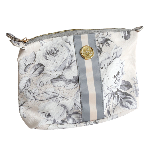 The Faded Rose Large Cosmetic is a durable cotton makeup bag with a white pouch, gray floral print, vertical gray/beige stripe, gold button detail, and zipper—perfect for travel or everyday use.