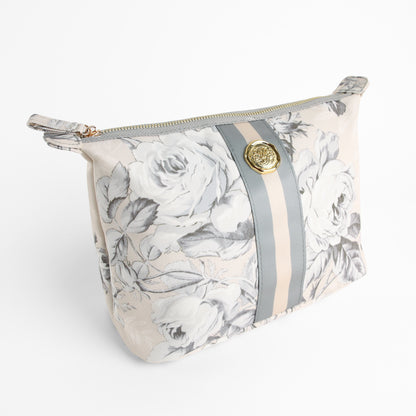 Introducing the Faded Rose Large Cosmetic Bag: Featuring a floral-patterned design with gray and beige stripes, a gold button accent, and a secure zipper closure, this elegant pouch is perfect for organizing your beauty essentials. Shown on a white background, the Faded Rose Large Cosmetic Bag combines style and functionality, making it an ideal choice as a travel cosmetic bag or spacious makeup organizer for any journey.