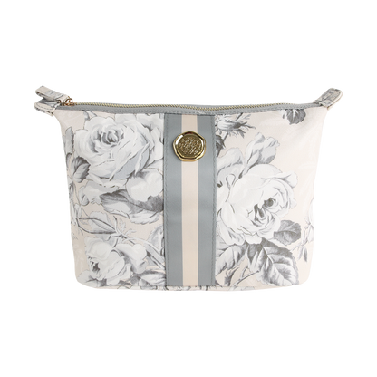 The Faded Rose Large Cosmetic Bag is a zippered makeup bag featuring a gray floral pattern, vertical light gray stripes, and a round gold emblem on the front.