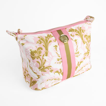 The Pink Damask Large Cosmetic Bag features a pink and gold floral pattern with pink and olive green vertical stripes on the front, a zippered closure, and a gold button detail. This elegant makeup bag is photographed on a white background.