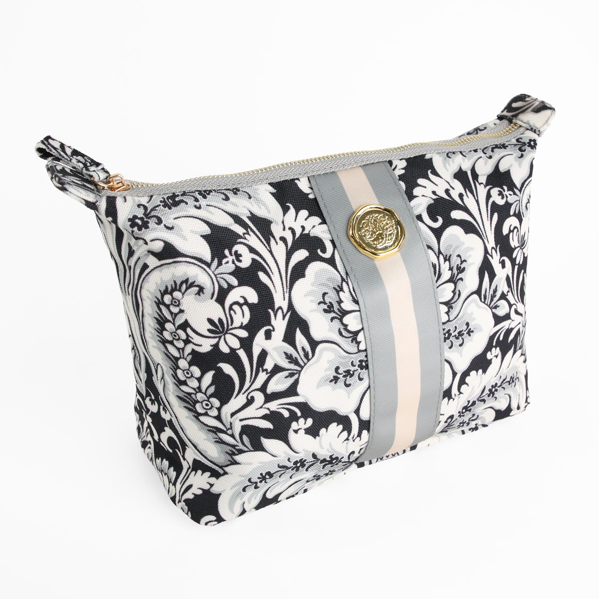 The Damask Noire Large Cosmetic Bag features a black and white floral design with beige and gray stripes, accented by a round gold emblem on the front. Displayed on a white background, this stylish large makeup bag is perfect for organizing your essentials at home or on the go.