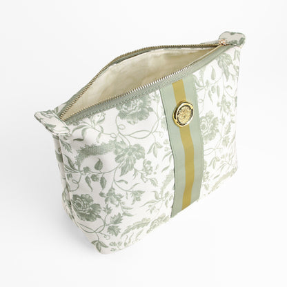 The Green Climbing Rose Large Cosmetic Bag features a green floral pattern with climbing roses, a gold zipper, green and gold vertical stripe, and a round gold medallion on the front.