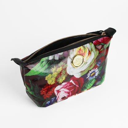 The Astrid Small Cosmetic Bag showcases a vibrant floral botanical print and a gold circular emblem on the front, set against a white background—making it an ideal travel accessory for keeping your essentials organized.