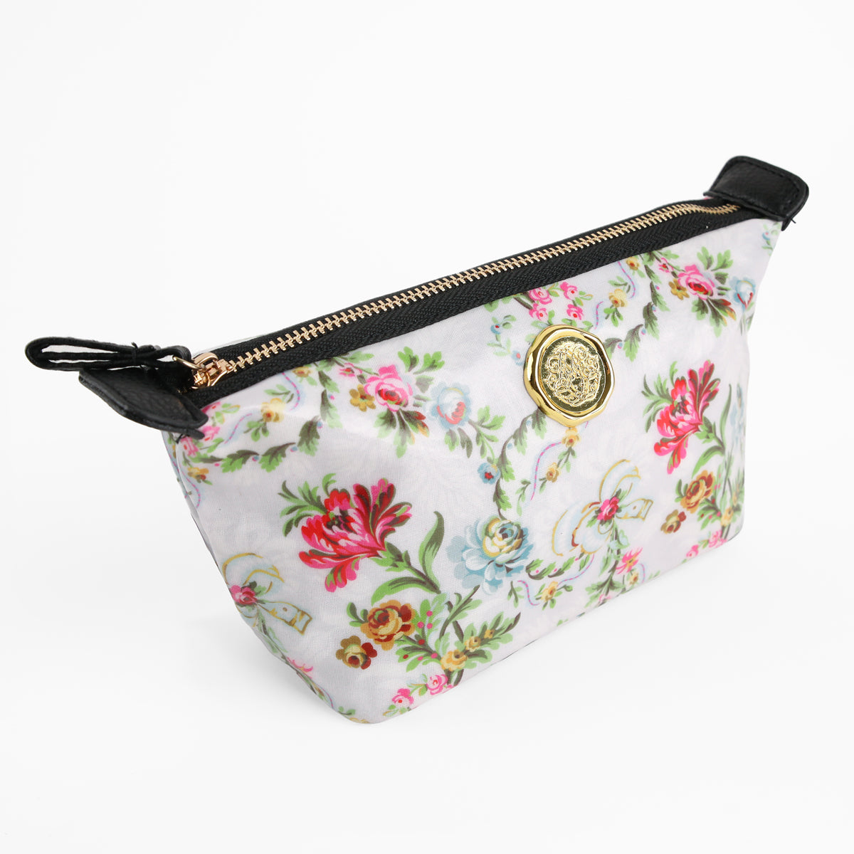 The Phoebe Small Cosmetic Bag features a floral pattern, black trim, and a gold medallion emblem. Ideal for everyday essentials, this compact makeup pouch combines style and functionality for organized beauty on the go. Displayed on a white background, it’s perfect for keeping your cosmetics neatly stored.