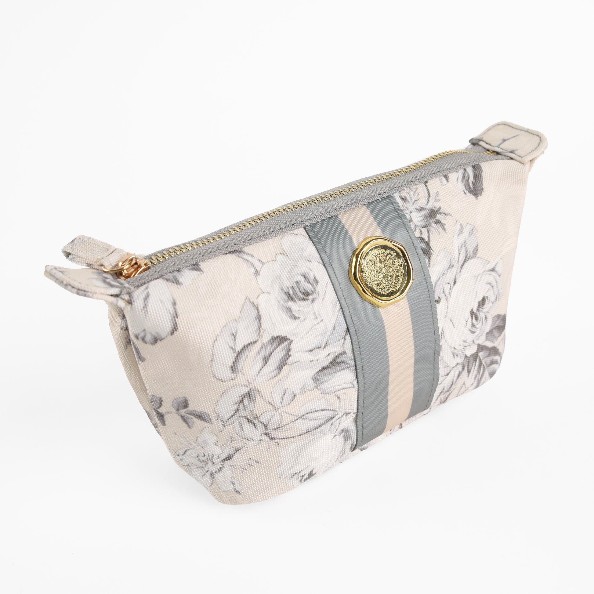 The Faded Rose Small Cosmetic Bag features a beige floral design with gray and cream stripes and a gold decorative emblem, making it a stylish choice for use as a floral makeup bag or travel pouch, shown here on a white background.
