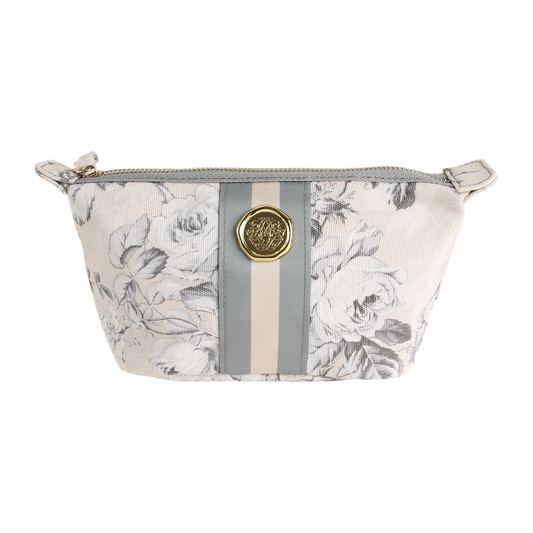 Introducing the Faded Rose Small Cosmetic Bag—a stylish zippered pouch showcasing a gray and white floral pattern, accented with vertical gray and beige stripes and finished with a gold medallion detail on the front. Perfect as a chic cosmetic pouch or a convenient travel bag.