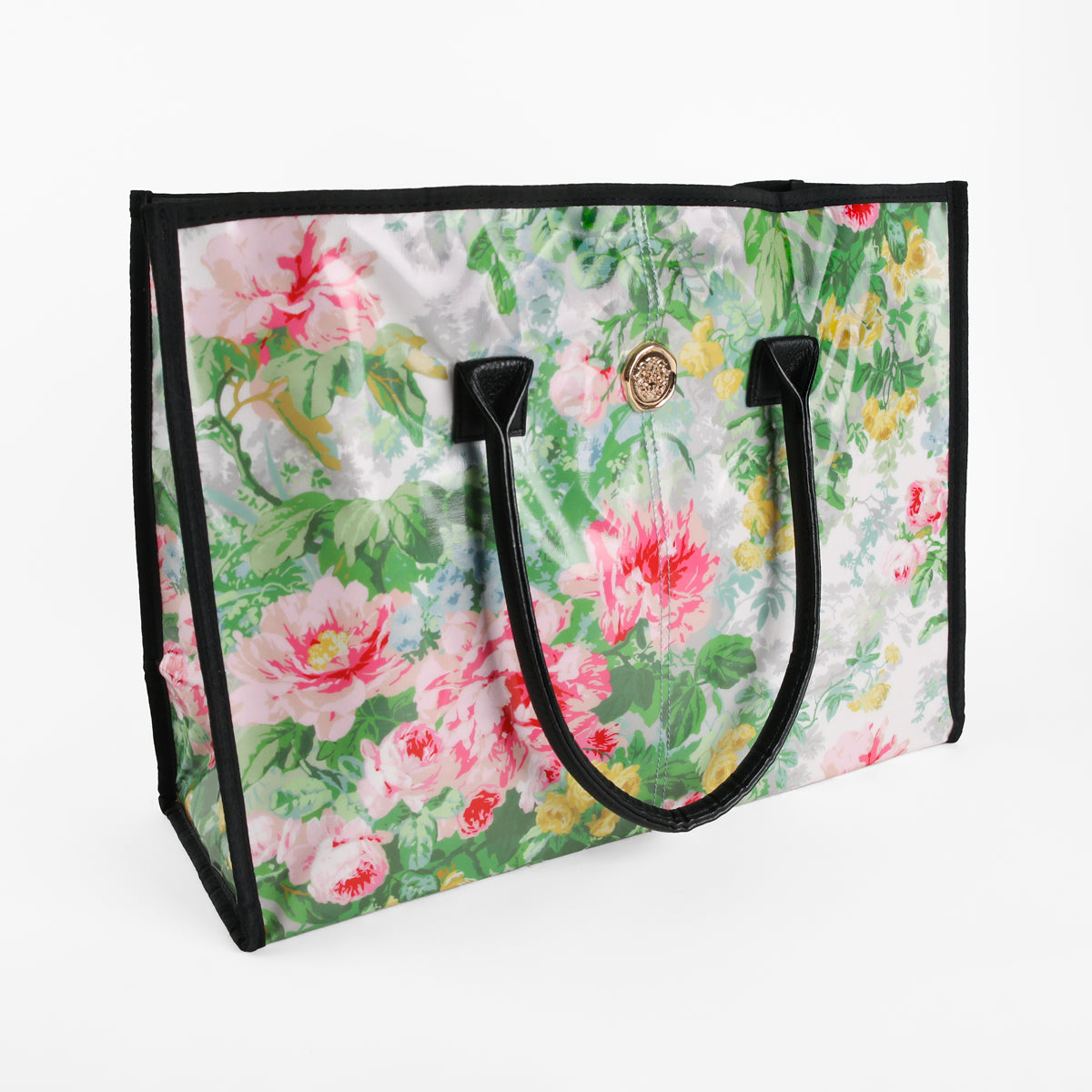 The Virginia Tote Bag is a spacious floral tote with black handles, showcasing a vibrant pink, green, and white floral pattern and finished with a round gold emblem near the top. Made from laminated cotton, this bag combines style and durability for everyday use.