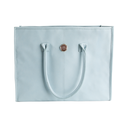 Introducing the Beach Glass Blue Tote Bag, a large shoulder bag crafted from high-quality faux leather for exceptional style and durability. This tote features two sturdy handles, a textured surface, and a striking round gold emblem centered on the upper front panel, all showcased against a clean white background.