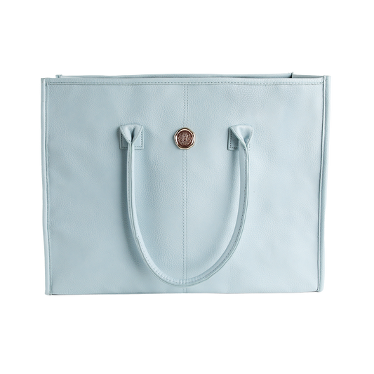 Introducing the Beach Glass Blue Tote Bag, a large shoulder bag crafted from high-quality faux leather for exceptional style and durability. This tote features two sturdy handles, a textured surface, and a striking round gold emblem centered on the upper front panel, all showcased against a clean white background.