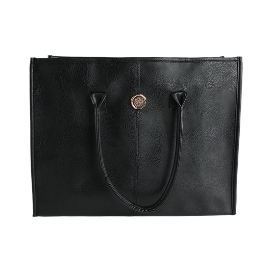 The Onyx Black Tote Bag is a spacious everyday accessory crafted from sleek black faux leather, featuring two sturdy handles and a small round gold emblem on the front. Photographed against a white background, this stylish tote for women is perfect for carrying all your daily essentials.