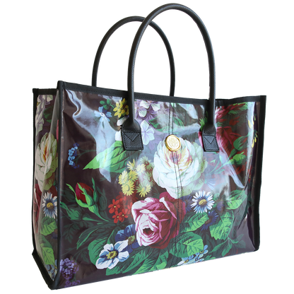 Transparent Astrid tote bag with a colorful floral print and black handles.