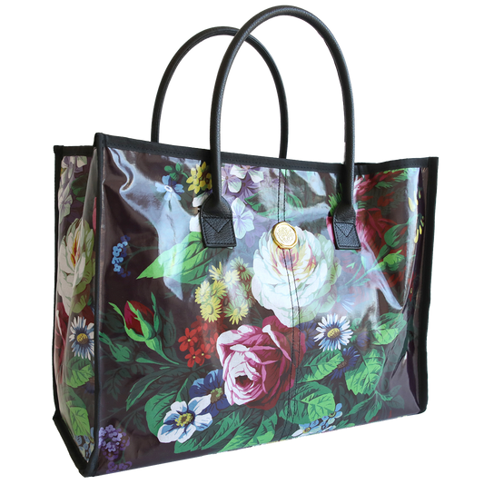 Transparent Astrid tote bag with a colorful floral print and black handles.