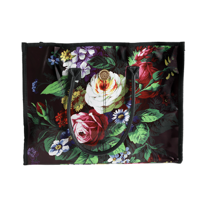 The Astrid Tote Bag is a spacious black laminated cotton tote for women, showcasing a vibrant floral pattern with roses, daisies, and green leaves. Featuring two sturdy black handles, this stylish floral tote bag is perfect for everyday use.