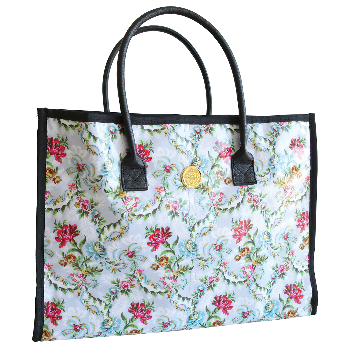 Phoebe Tote Bag with black handles and a circular gold emblem on the front, isolated on a white background.