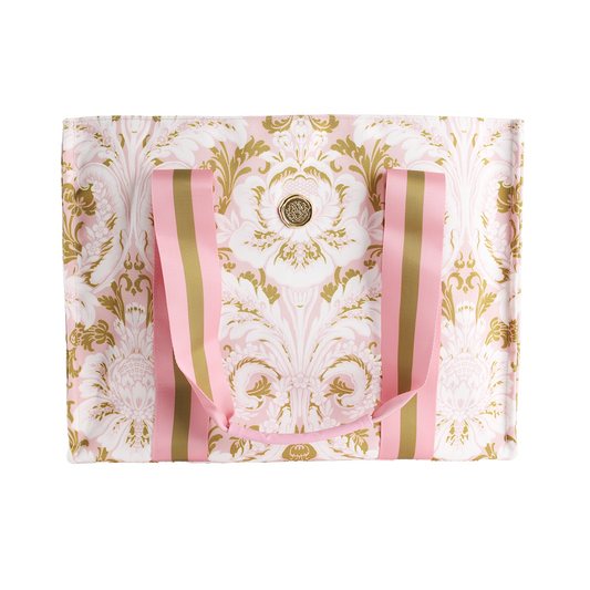 Introducing the Pink Damask Tote Bag: an elegant large canvas tote adorned with a pink and gold baroque floral pattern. This stylish bag features pink and gold striped handles and is accented by a circular gold emblem at its center, making it the perfect choice for a floral market trip or elevating your everyday look with a touch of luxury.