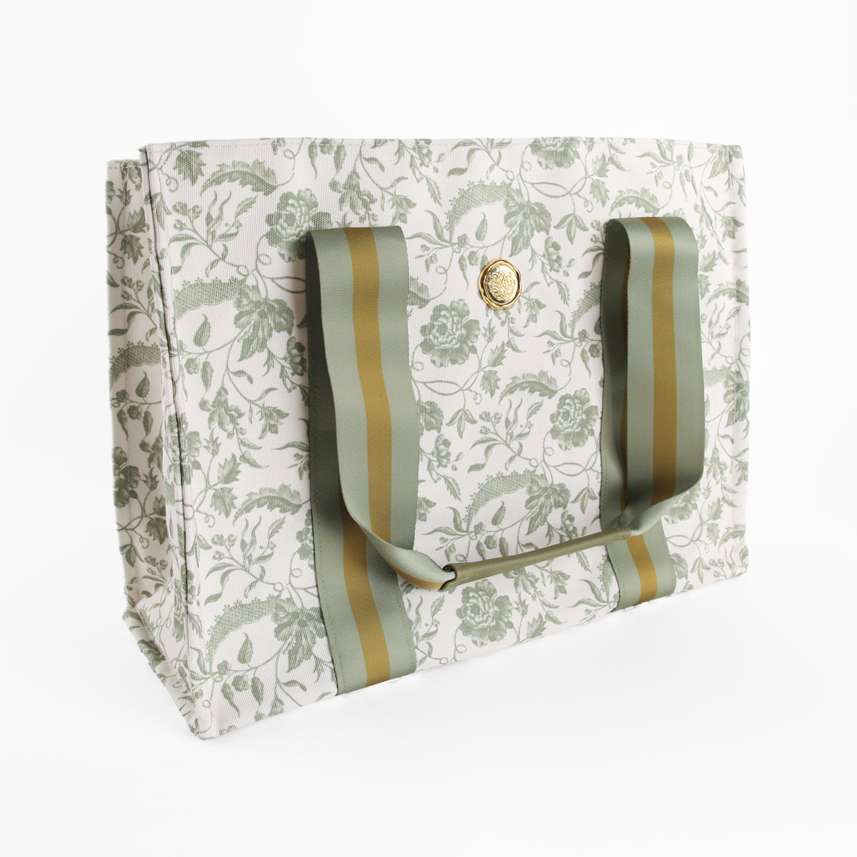 The Green Climbing Rose Tote Bag features white fabric adorned with a green botanical rose print, wide green and beige striped handles, and a gold circular emblem on the front. Displayed on a white background, it’s an ideal canvas market bag and a charming botanical gift for women.