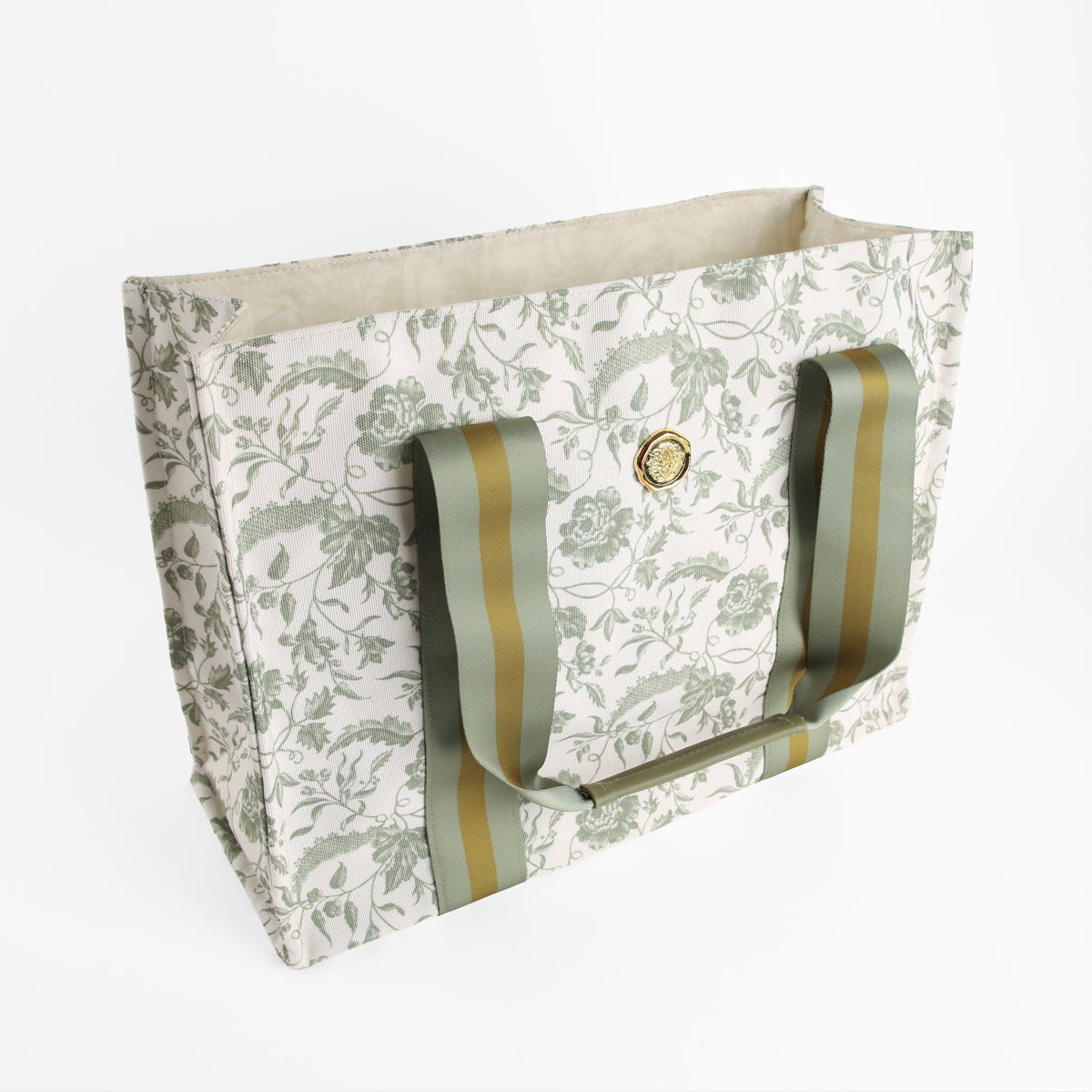 Green Climbing Rose Tote Bag featuring a rectangular shape, green climbing rose floral pattern, wide green striped handles, and a gold circular emblem on the front, displayed on a white background. This stylish canvas market bag makes an ideal botanical gift for women.