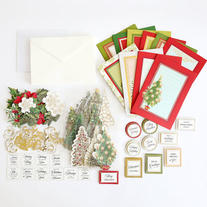 The Folded Christmas Tree Card Making Kit features a variety of supplies for handmade Christmas cards, including blank cards, envelopes, festive stickers, tree and holly cutouts, and assorted holiday greetings—all neatly arranged on a white surface. This kit provides everything you need to create unique folded Christmas tree cards and share holiday cheer.
