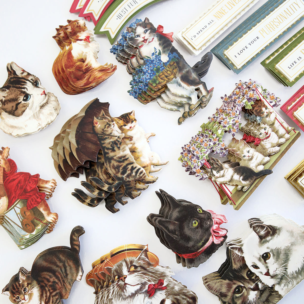 A collection of Fur Baby Cat Stickers and Sentiments, including cats in different poses and with accessories, spread out on a light surface for cat lovers.