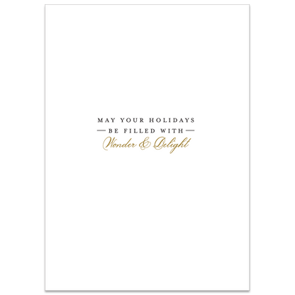 The Traditional Tree Boxed Card 10 ct features a white holiday card adorned with the message "May your holidays be filled with wonder & delight" in black and gold text. This card boasts a simple, elegant design enhanced by specialty finishes, adding an extra touch of sophistication.