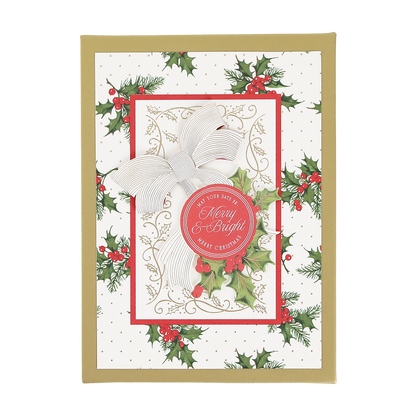 Elevate your holiday card collection with the Heirloom Holly Boxed Cards 10 ct, featuring a stunning design with a gold border, festive holly decorations, a white and gold bow, and a red circle that reads “Merry & Bright.” The elegant background is adorned with small gold dots for an extra festive touch.