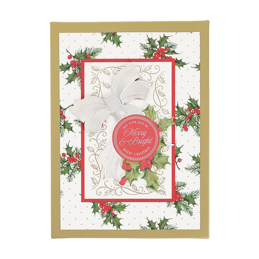 Elevate your holiday card collection with the Heirloom Holly Boxed Cards 10 ct, featuring a stunning design with a gold border, festive holly decorations, a white and gold bow, and a red circle that reads “Merry & Bright.” The elegant background is adorned with small gold dots for an extra festive touch.