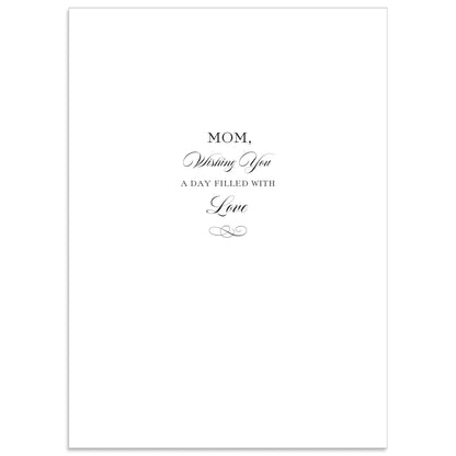 The Best Mom Ever Card is a 5" x 7" white card with black text saying, "Mom, Wishing You A Day Filled With Love" and features a gold foil flourish. It comes with a printed lined envelope for an elegant touch.