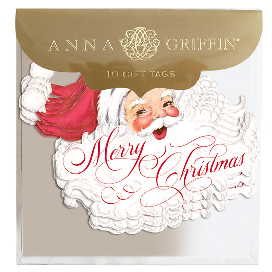 A packaged set of 10 gift tags, labeled "Merry Santa Tag 10 ct," features a Santa Claus illustration with "Merry Christmas" written in red script and is branded by Anna Griffin.