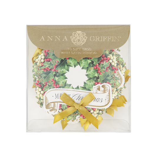 A package of Mistletoe Wreath Tag 10 ct features festive Christmas gift tags shaped like wreaths, adorned with gold ribbons and a visible “Merry Christmas” banner on the front. These elegant tags add a sophisticated touch to your holiday gifts.