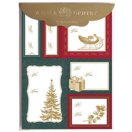 The Gold Christmas Icon Labels 72ct features festive stickers with classic holiday designs—tree, sleigh, gift box, and pine branches—all with "To:" and "From:" fields and elegant gold foil accents.