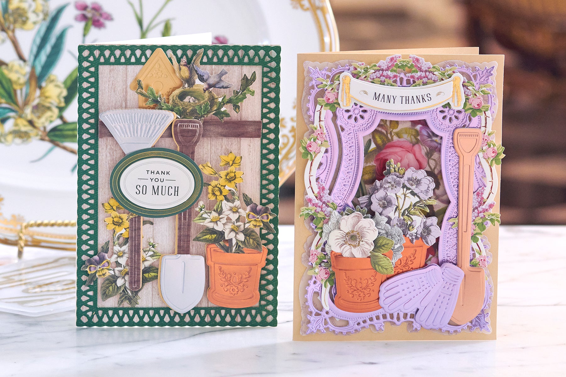 Two intricately designed greeting cards displayed on a table, one with a gardening theme and the other floral, expressing gratitude.