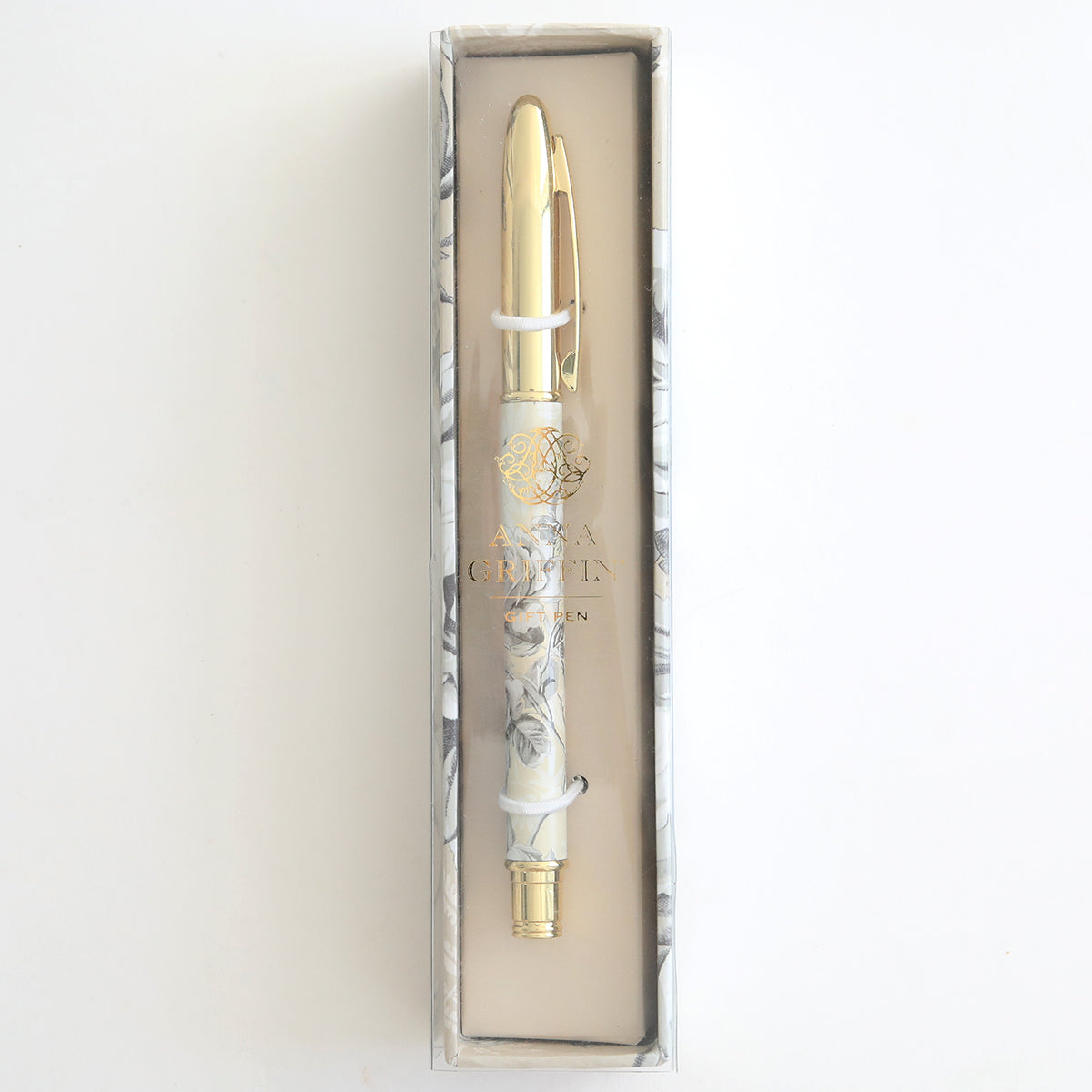 The Faded Rose Gift Pen, featuring a floral pattern with gold accents, is perfect for stationery enthusiasts. Elegantly housed in a marble-patterned box, this decorative ballpoint pen stands vertically against a light background, blending style and sophistication seamlessly.