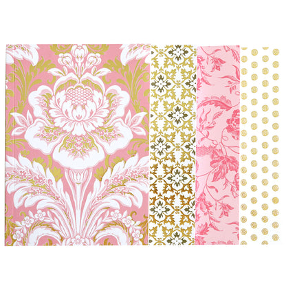 The Pink Damask Notebook Set features a spiral journal with five distinct decorative paper panels: pink floral, gold floral, pink floral with birds, pink with gold flowers, and gold dots on white. The lined pages are elegantly accented with shimmering gold foil.