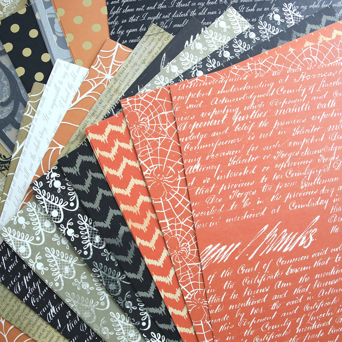 A variety of patterned paper sheets fanned out, featuring designs including text, zigzags, polka dots, spider webs, and foliage in colors like black, orange, white, and gray. This spooktacular Haunted Halloween 12x12 Cardstock collection is perfect for all your crafting needs.