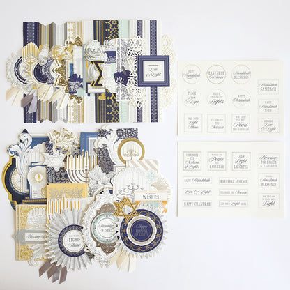 Hanukkah Card Toppers and Sentiments in blue, gold, white, and cream are arranged neatly on a white background, featuring assorted decorative elements and stickers for card making.