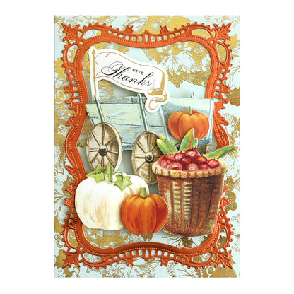 Greeting card featuring Harvest Embellishment Stickers, a “Give Thanks” sign, a wooden cart, pumpkins, a basket of cranberries, and an ornate orange frame set against a gold floral patterned background—beautifully finished with charming dimensional details.
