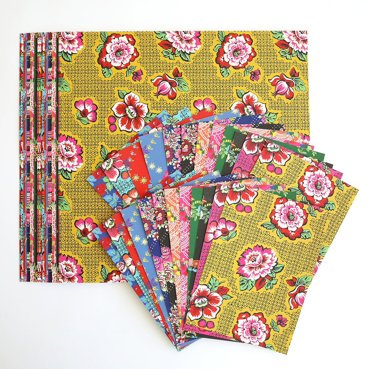 A display of colorful, floral patterned papers fanned out on a larger sheet of Hermosa Multi Cultural Cardstock, set against a white background.