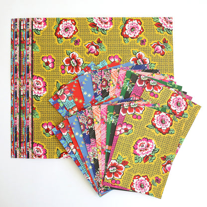 A display of colorful, floral patterned papers fanned out on a larger sheet of Hermosa Multi Cultural Cardstock, set against a white background.