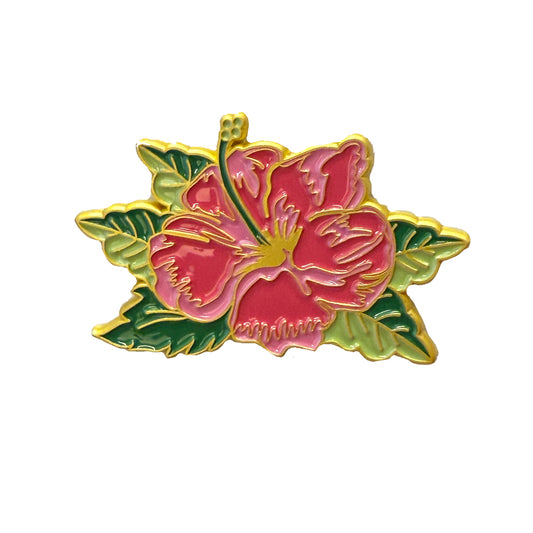 The Members Only July Pin features a gold-outlined enamel pink hibiscus flower with green leaves on a white background, and is part of our Exclusive Pins collection for 2025.