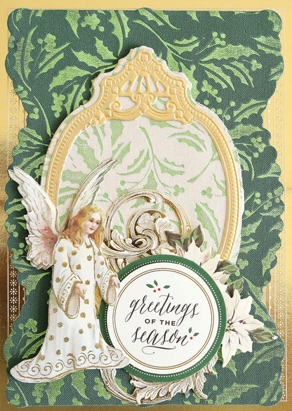 Featuring Holiday Fabric Card Layers, this holiday card showcases an angel illustration framed in ornate gold, a circular “greetings of the season” label encircled by poinsettia flowers, and a green patterned background. Perfect for Christmas card making, these fabric layers add rich texture and elegance to your design.