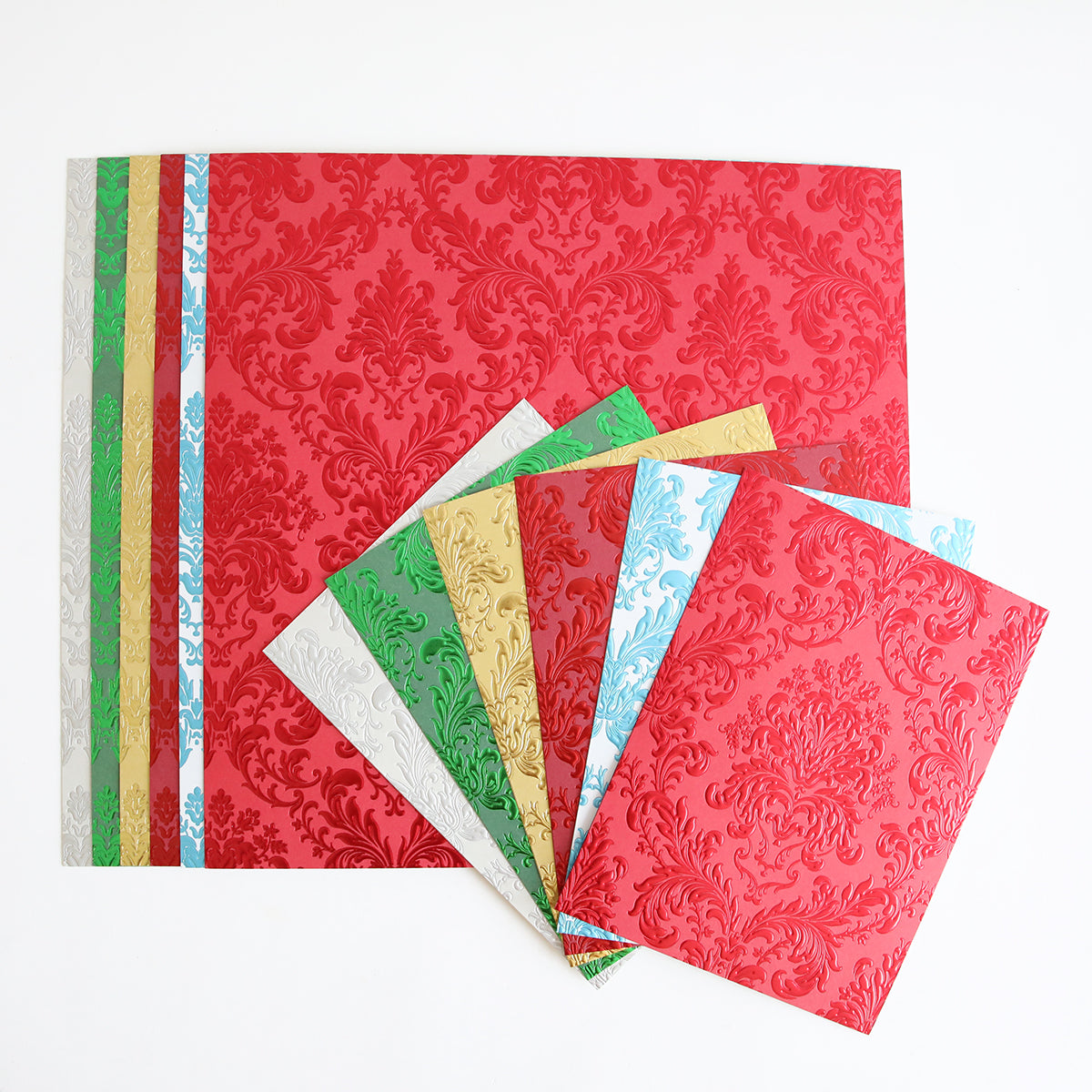 Radiant Holiday Wreath and Bow Bundle featuring rectangular holiday foil cardstock in red, green, gold, white, and light blue, each with a raised damask pattern ideal for Christmas card making.