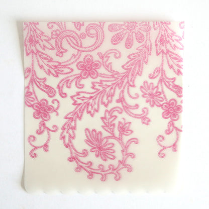 The Pink Lace Vellum Wrap 10 pack features square, translucent sheets with pink floral and leaf patterns, intricate swirls, and a scalloped bottom edge—ideal for elegant wedding invitation wraps and displayed on a white background.