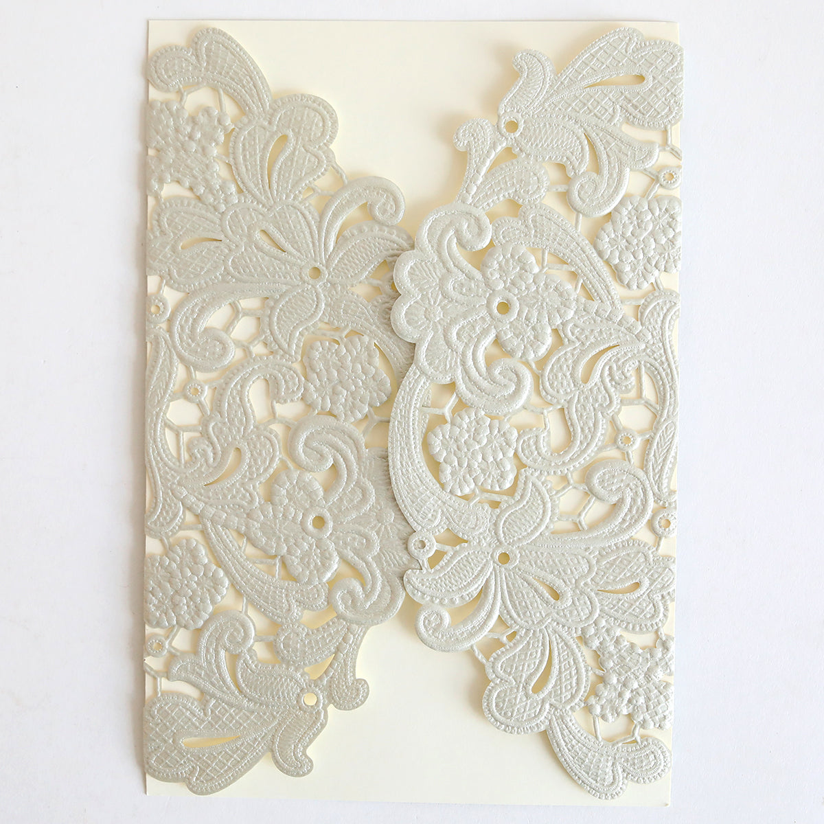 The Silver Embossed Lace Gatefold 10 pack features cream-colored wedding invitations with intricate floral and paisley lace designs, embossed gatefolds, and a subtle silver shimmer on a white background.