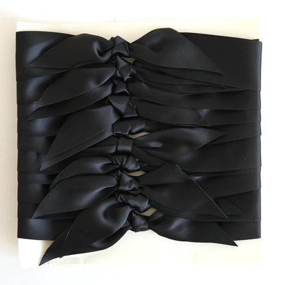 Ten pre-tied black satin knots are arranged in parallel rows on a white background—ideal for adding a stylish touch to handmade cards or crafts.