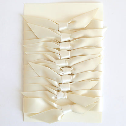 A stack of Ivory Satin Knots 10 count handmade cards, each tied with double-faced satin bows, arranged vertically on a white background.