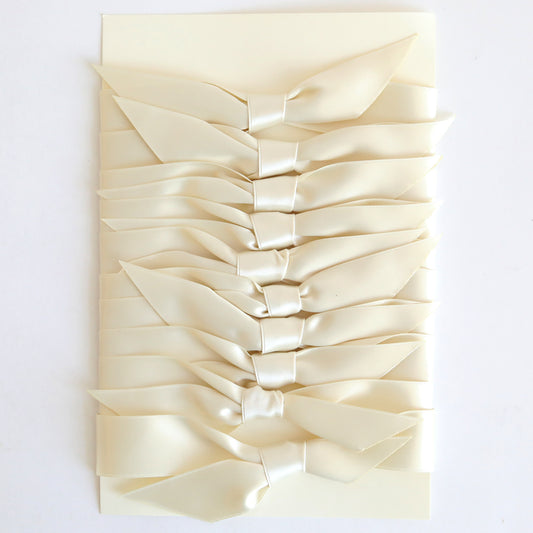A stack of Ivory Satin Knots 10 count handmade cards, each tied with double-faced satin bows, arranged vertically on a white background.